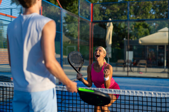 Woman celebrating padel victory with partner on court