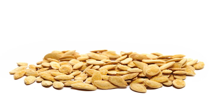 Pile roasted pumpkin seeds with salt isolated on white background