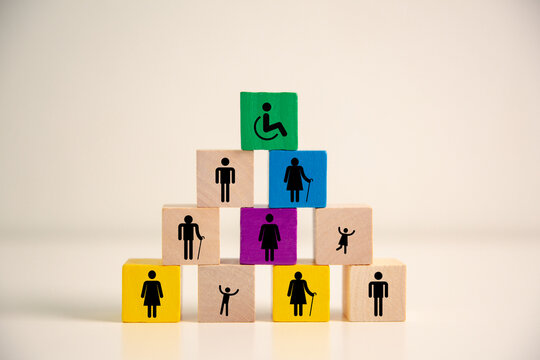 Colorful wooden blocks with accessibility, disability, senior, adult and child icons arranged as a pyramid, symbolizing inclusion, diversity, equal rights, community support and social care. equality