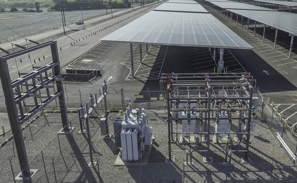 Aerial view of the electrical interconnection facility for Six Flags Magic Mountain, featuring a transformer and solar panel parking canopy in Santa Clarita, California, United States.