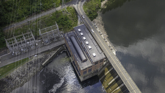 Aerial view of Stevenson Generating Station featuring the hydroelectric powerhouse, electrical substation, switchyard, and adjacent road bridge in Monroe, CT, United States.