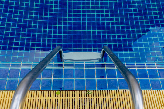 Ladder stainless handrails for descent into swimming pool.