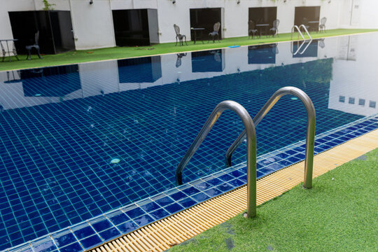 Ladder stainless handrails for descent into swimming pool.