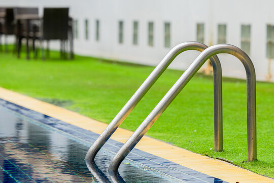 Ladder stainless handrails for descent into swimming pool.