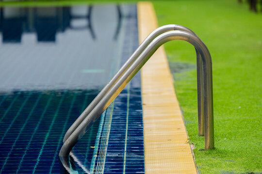 Ladder stainless handrails for descent into swimming pool.