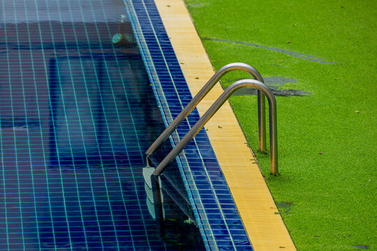Ladder stainless handrails for descent into swimming pool.