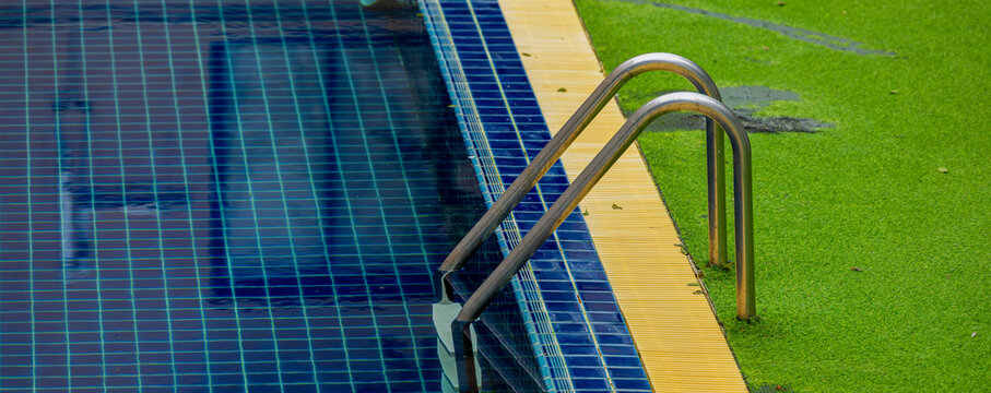 Ladder stainless handrails for descent into swimming pool.