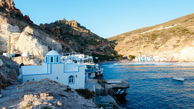 Stunning seascape of Firopotamos village in Milos, Greece during golden hour light