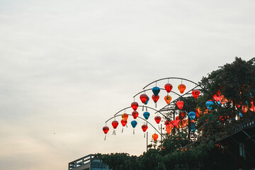 夕暮れの空に映えるアーチ飾りのカラフルなランタン © YUSUKE SAKAI