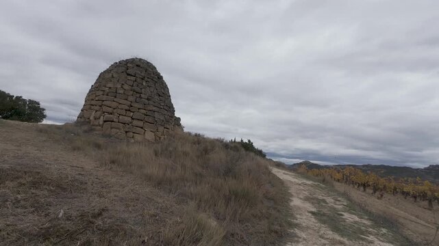 Walking towards an ancient stone hut in a rural landscape