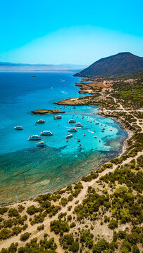 Vertical aerial view of the rocky coastline and boats in Cyprus Blue Lagoon.