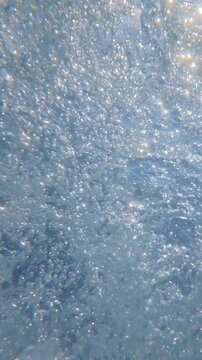 Underwater ocean water bubbling and churning near surface