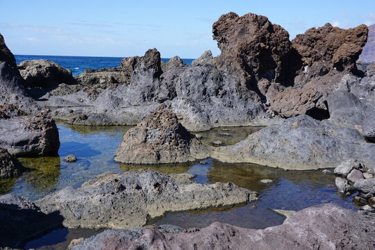 Volcanic rock pools with clear water on a rugged coastline