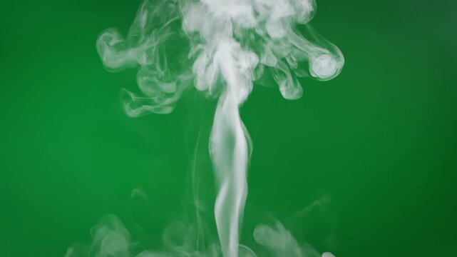 A plume of white smoke rises against a vibrant green backdrop, creating an ethereal and abstract visual effect. The wisps of smoke twist and curl, forming dynamic shapes that captivate the eye.