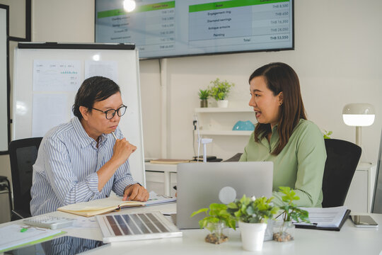 A diverse group of business professionals working together in a modern office, analyzing environmental data and charts to develop eco-friendly, sustainable corporate strategies.