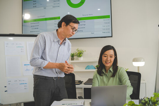 A diverse group of business professionals working together in a modern office, analyzing environmental data and charts to develop eco-friendly, sustainable corporate strategies.