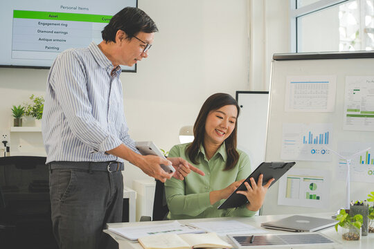 A diverse group of business professionals working together in a modern office, analyzing environmental data and charts to develop eco-friendly, sustainable corporate strategies.
