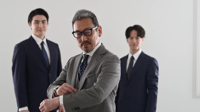 腕を組んで立つ50代の日本人ビジネスマンと30代の部下