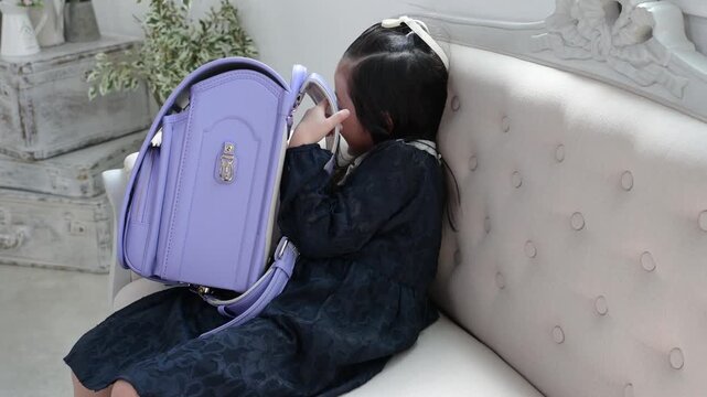 ランドセルに隠れて遊ぶ6歳の日本人女の子
