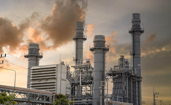 Industrial power plant emitting smoke stacks at sunset, Concept of air pollution, carbon emissions, and climate change.