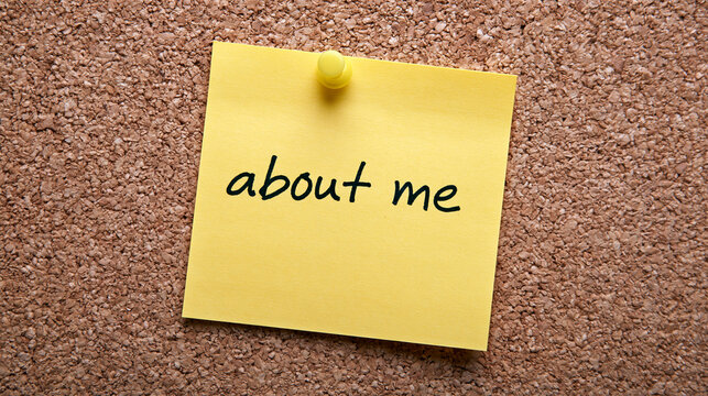 A yellow sticky note with the text about me pinned to a cork board. Ideal for professional biography or personal.