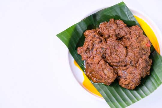 Rendang is traditional food from West Sumatra, Indonesia. It is made from beef stew and coconut milk with various herbs and spice. Isolated on white background