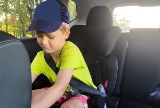 child adjusting seatbelt in car interior side view neutral mood family travel safety green blue commercial natural light clean background copy space editorial educational visual story web.