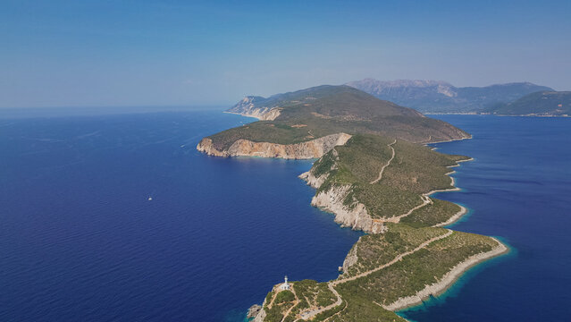 Aerial view of Cape Lefkata narrow peninsula with white lighthouse on cliff edge surrounded by blue Ionian sea water Lefkada island Greece travel landscape photo