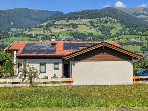 house in the mountains with solar panels on the roof