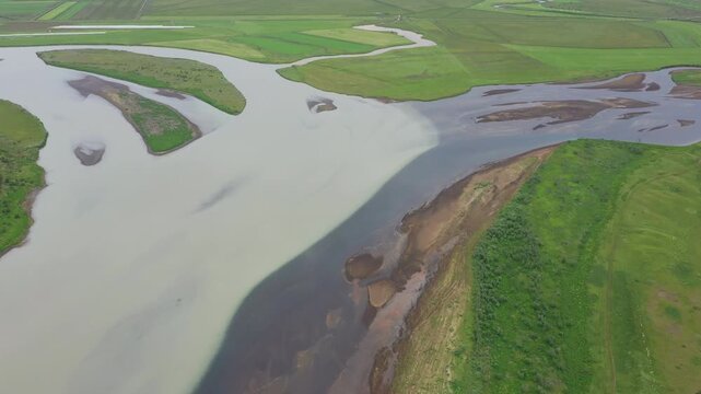 Water from glacier and clear mountain water meet in the river Stora Laxa, Iceland