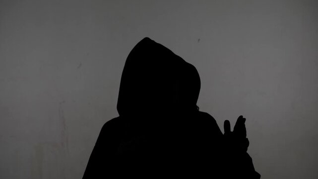 Close-up of an anonymous silhouette of a person giving an interview against a white background