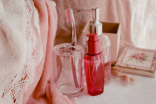 Wellness and beauty routine essentials with pink towel, toothbrush, and skincare products, creating a calm atmosphere for daily self care and hygiene