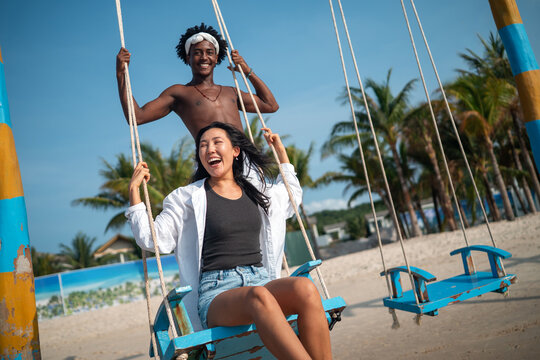Stylish young multiethnic people in trendy summer outfits enjoying a sunny day at a beach resort