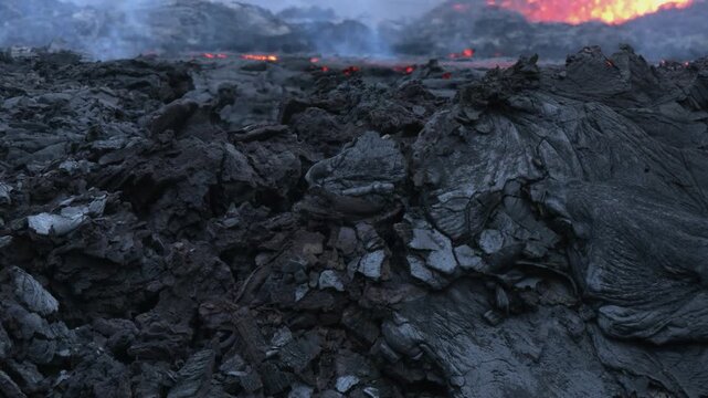 Volcanic eruption in Iceland 2021 at night. At the edge of the lava flow, mixture of solid lava and molten magna