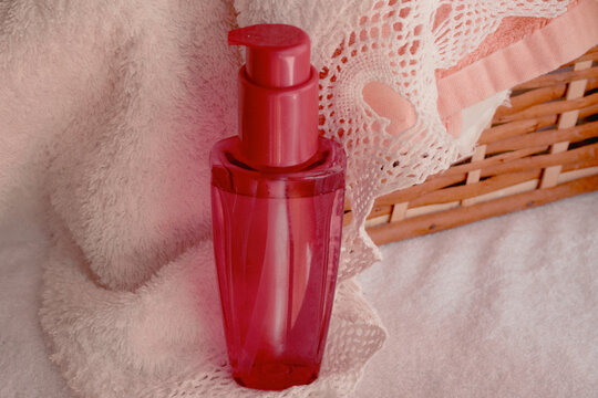 Pink pump bottle standing on soft white towel, offering skincare and selfcare products for wellness, beauty, and a serene spa experience