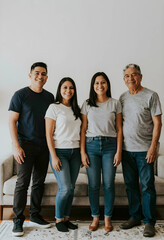 Obraz premium Happy multi-generational hispanic family portrait standing together in a bright living room at home
