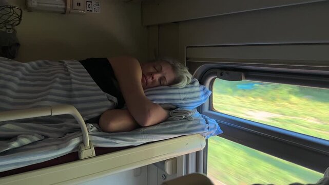 Senior woman resting on upper berth in train during morning trip, vacation and tourism marketing, comfortable railway transport, serene journey.