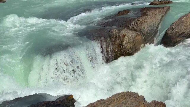 Beautiful view on the powerful Kicking Horse River in Yoho National Park. Canada. British Columbia,. Water flows rapidly over rocks in a river, creating white foam and splashes in a natural outdoor se