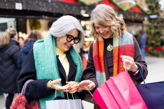 Senior women friends enjoying holiday shopping at market