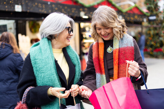 Senior women friends shopping enjoying holiday market