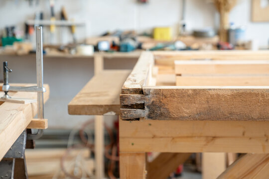 Vintage frame at workbench in restoration workshop with signs of rot and damage due to precipitation, preparation process before replacement and repair of damaged parts on wooden window frame.