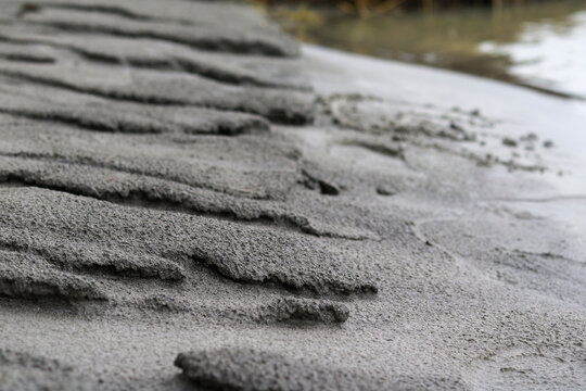Close Up Texture of Eroded Wet Sand near River Bank
