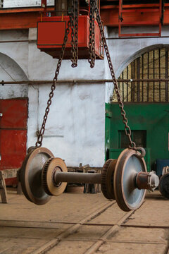 Heavy Industrial Train Wheelset Suspended by Steel Chains in Workshop