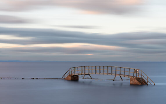 Long Exposure of Belhaven Bridge at high tide beneath a cloudy sky, Dunbar, East Lothian, Scotland