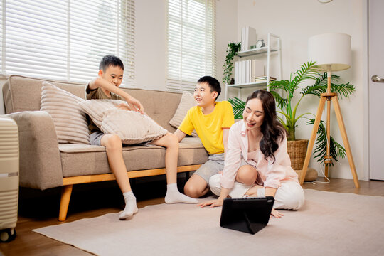 Mother teaching music to her children while playing guitar at home