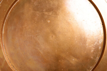 Detailed abstract texture of aged brass with visible patina and subtle circular patterns