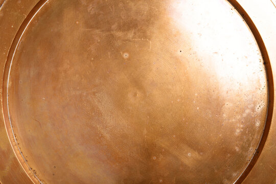 Detailed abstract texture of aged brass with visible patina and subtle circular patterns