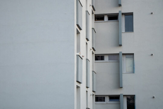 Minimalist Apartment Building Facade With Copy Space And Two Cats Peeking From Balcony