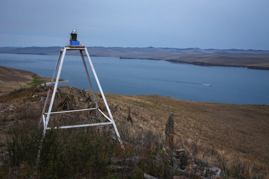 Coastal navigation light beacon standing on island shore at Lake Baikal, Siberia, Russia