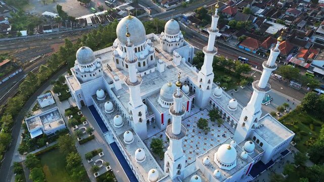 Aerial view of Sheikh Zayed Grand Mosque with its white domes and minarets surrounded by urban landscape in Surakarta, Jawa Tengah, Indonesia.